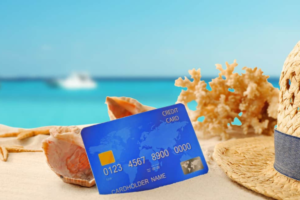Travel credit card beside seashells overlooking the ocean